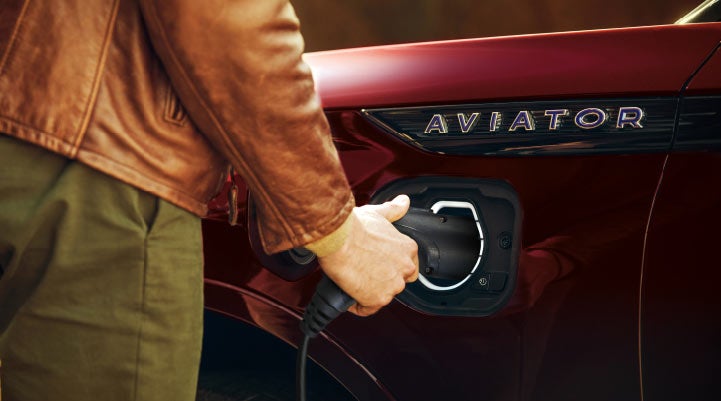 A hand is shown plugging in the charger into the charging port of a 2021 Lincoln Aviator | Magic City Lincoln in Roanoke VA