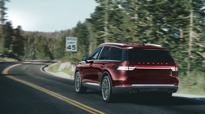 A 2024 Lincoln Aviator® SUV is being driven on a winding mountain road | Magic City Lincoln in Roanoke VA